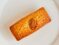 Delicate almond cake elegantly presented on a branded white plate.